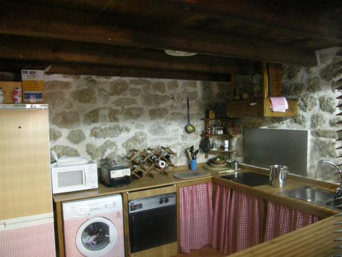a kitchen with a sink and a stove and a microwave at Posada del Dulce Sueño in Mojares
