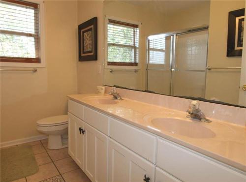 ein Badezimmer mit Waschbecken, Toilette und Spiegel in der Unterkunft Watercolors in Edisto Island