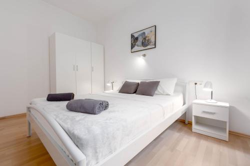 białe łóżko z dwoma poduszkami w sypialni w obiekcie Bora Apartment Pula w Puli