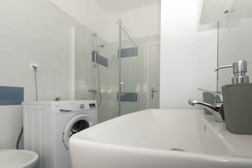 biała łazienka z pralką i umywalką w obiekcie Bora Apartment Pula w Puli