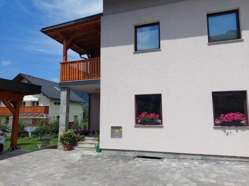 un edificio blanco con dos ventanas con flores. en Apartma Mango, en Bled