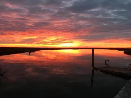 a sunset over a body of water with a dock at Whitmarsh in Edisto Island