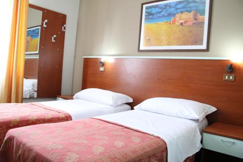 a hotel room with two beds and a mirror at Hotel MM Dateo in Milan
