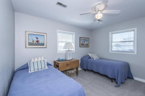 a bedroom with two beds and a ceiling fan at Escape in Edisto Island