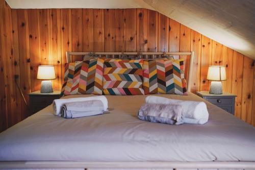 a bedroom with a bed with two pillows and two lamps at Casa do Avô Horácio in Carreço