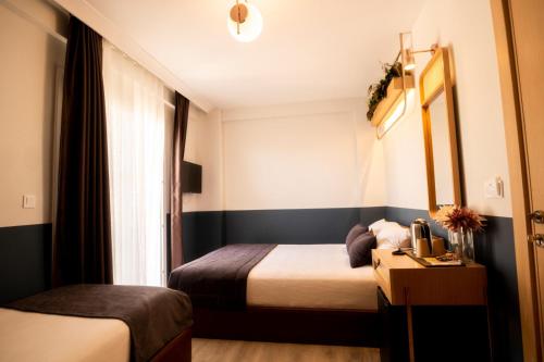 a hotel room with two beds and a window at Urla 1867 Hotel in Urla
