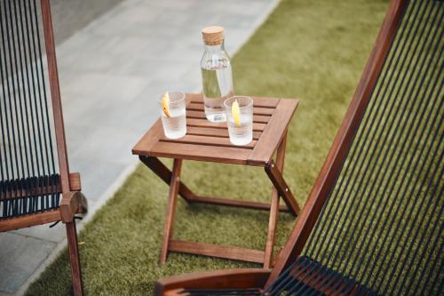 a wooden table with a bottle and two glasses on it at AVA HOUSE in Kranjska Gora