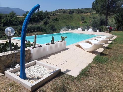 a swimming pool with a bunch of chairs next to it at Villa Greco in Rossano
