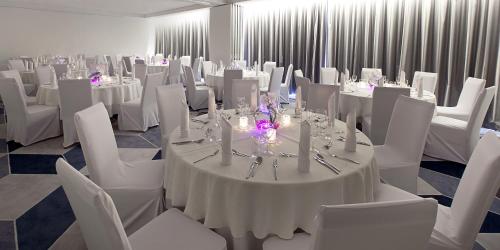 a ballroom with white tables and chairs and white tables and white chairs at Novotel Katowice Centrum in Katowice