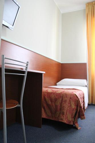 a bedroom with a bed and a table and a chair at Hotel MM Dateo in Milan