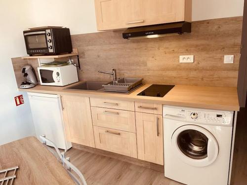een keuken met een wasmachine en een magnetron bij Superbe appartement à la croisée des 4 Châteaux in Lignières-de-Touraine