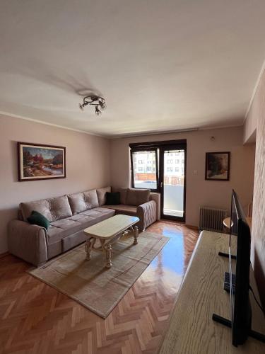 uma sala de estar com um sofá e uma mesa de centro em Apartment 777 em Bijelo Polje