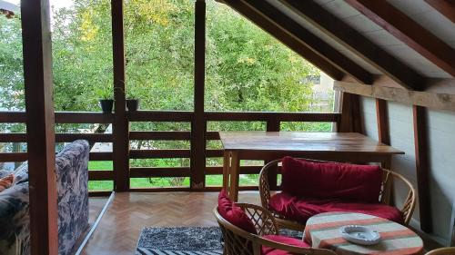 a screened in porch with a table and chairs at Apartmani Odmor i Mir in Vranje
