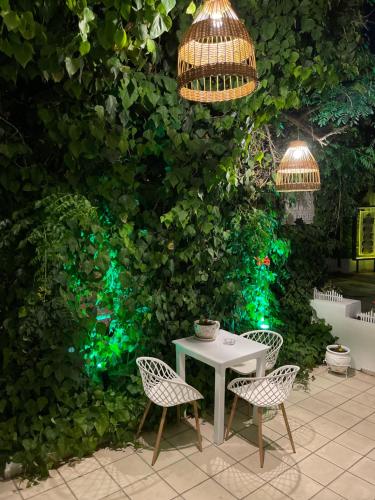 a table and chairs in front of a green wall at Matala View in Matala