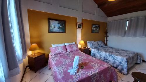 1 dormitorio con 2 camas con sábanas rosas en Flats Tartaruga Búzios, en Búzios