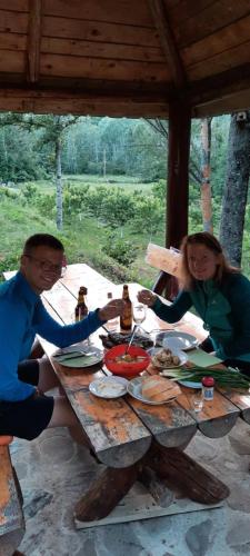 a man and a woman sitting at a picnic table at Holiday bungalows Pajkovir in Kolašin