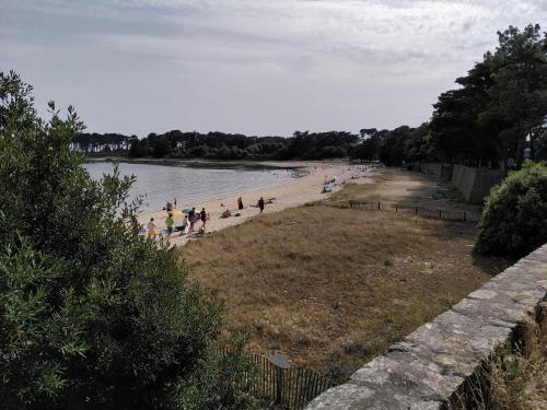 a group of people on a beach in the water at Appartement T2 tout équipé à 100m de la mer in Saint-Philibert