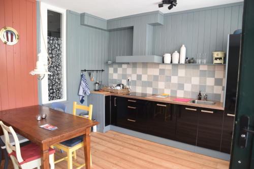 a kitchen with a wooden table and a dining room at Huisje onder de Linden in Munnekeburen