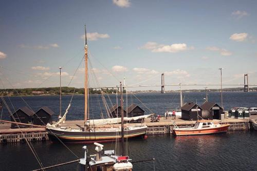 um grupo de barcos ancorados numa doca com uma ponte em Dock House 95-97 em Middelfart