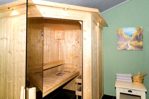 a wooden sauna in a bathroom with a painting at Celebration Wellnesshuisje in Balkbrug