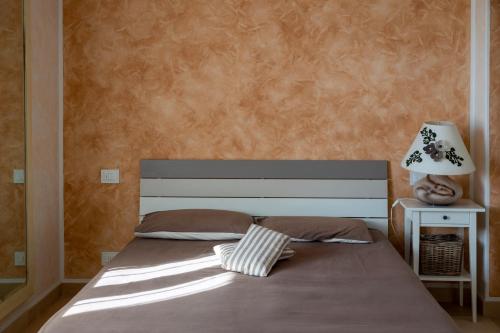 a bedroom with a bed with a lamp on a table at Cà da Cesare in Somendenna
