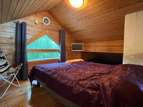 a bedroom with a bed and a window in a cabin at Koivuranta in Ähtäri