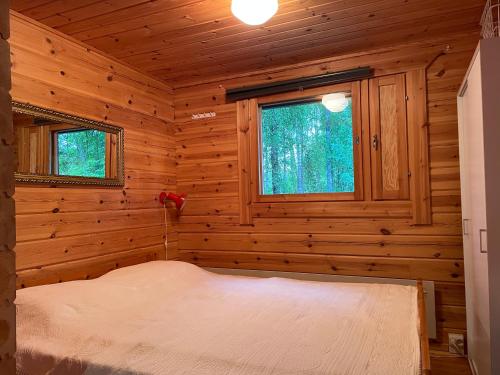 a bedroom with a bed in a log cabin at Koivuranta in Ähtäri
