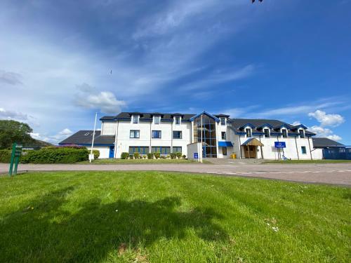 a large white building with black roof at Waterfront Lodge - Accommodation Only in Fort William
