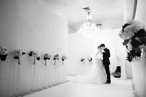 a bride and groom kissing in a room with flowers at Centara Grand at Central Plaza Ladprao Bangkok in Bangkok