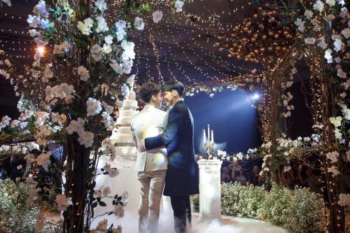 a bride and groom standing in front of a wedding altar at Centara Grand at Central Plaza Ladprao Bangkok in Bangkok