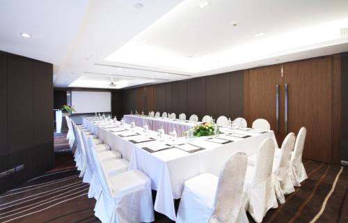 a long table with white tables and chairs in a room at Centara Grand at Central Plaza Ladprao Bangkok in Bangkok