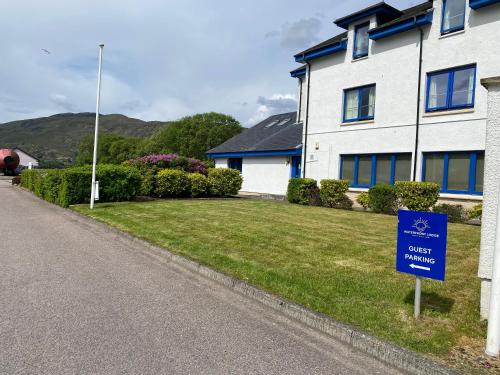 a house with a blue sign in front of it at Waterfront Lodge - Accommodation Only in Fort William