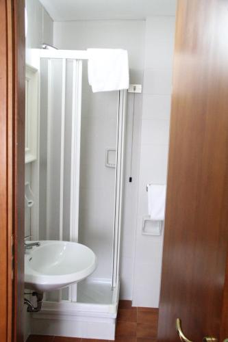 a bathroom with a shower and a white sink at Hotel MM Dateo in Milan