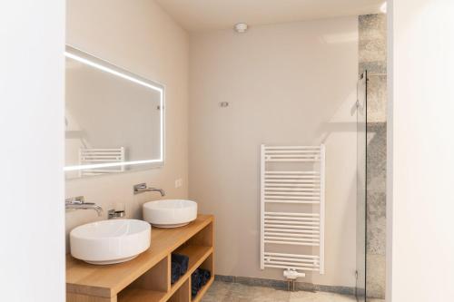 a bathroom with two sinks and a mirror at Luxe appartementen Havenzicht in Sint Annaland