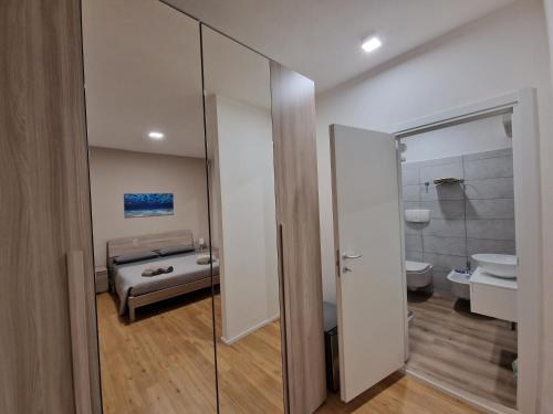 bagno con porta a vetri che conduce a una camera da letto di The Shell Guest House ad Alghero