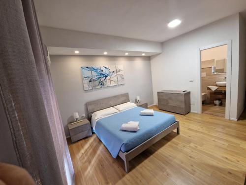 una camera con letto blu e un bagno di The Shell Guest House ad Alghero