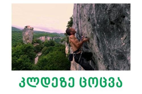 a young man is climbing a rock wall at Butichi Guest House in Chiatʼura