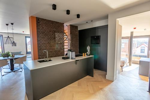 a kitchen with a sink and a brick wall at Luxe appartementen Havenzicht in Sint Annaland