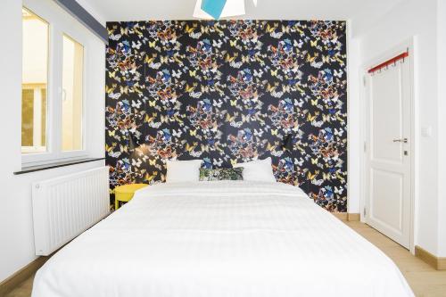 - une chambre avec un lit et un papier peint floral dans l'établissement Smartflats City - Perron, à Liège