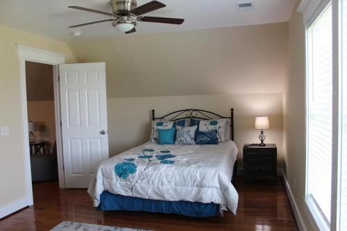una camera da letto con letto con cuscini blu e ventilatore a soffitto di Palmetto Hut a Edisto Island