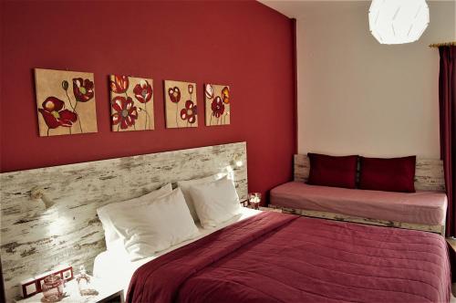 1 Schlafzimmer mit 2 Betten und roten Wänden in der Unterkunft Asmini Studios in Pefki