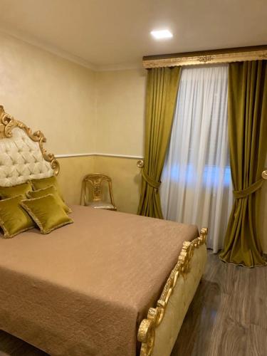 le 4 stelle luminose في Trinitapoli: غرفة نوم بسرير كبير مع ستائر خضراء