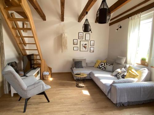 a living room with a couch and a tv at Domek pod lasem in Pasłęk