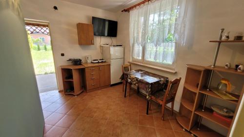 een keuken met een tafel en een koelkast bij Domek nad stawami dla wędkarzy - Gospodarstwo Rybackie Jaworznik in Jaworznik