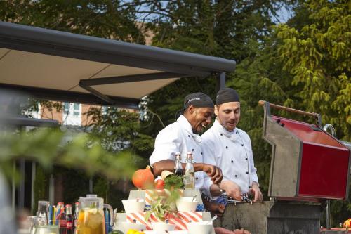 two chefs are preparing food on a table at Radisson Blu Hotel Karlsruhe in Ettlingen