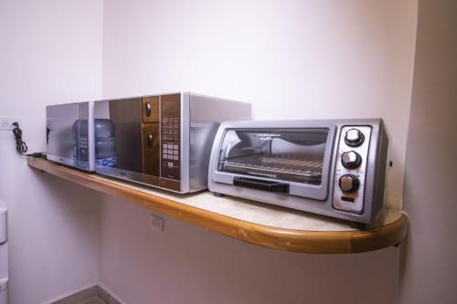 two microwaves are sitting on a shelf at La Mansión del Rey David in San Luis Potosí