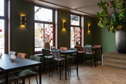 a restaurant with tables and chairs and windows at Luxe appartementen Havenzicht in Sint Annaland