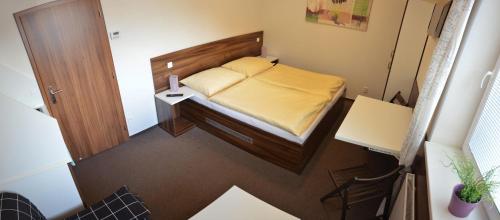 a small bedroom with a bed and a table at Apartmány - Kouty nad Desnou in Loučná nad Desnou