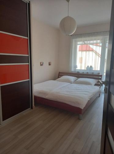 1 dormitorio con cama y ventana grande en Apartament ZOSIA, en Korczyna
