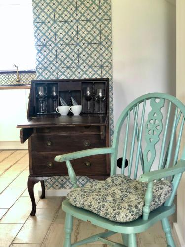 a green chair sitting in front of a wooden desk at Goose Home and Garden in Łeba
